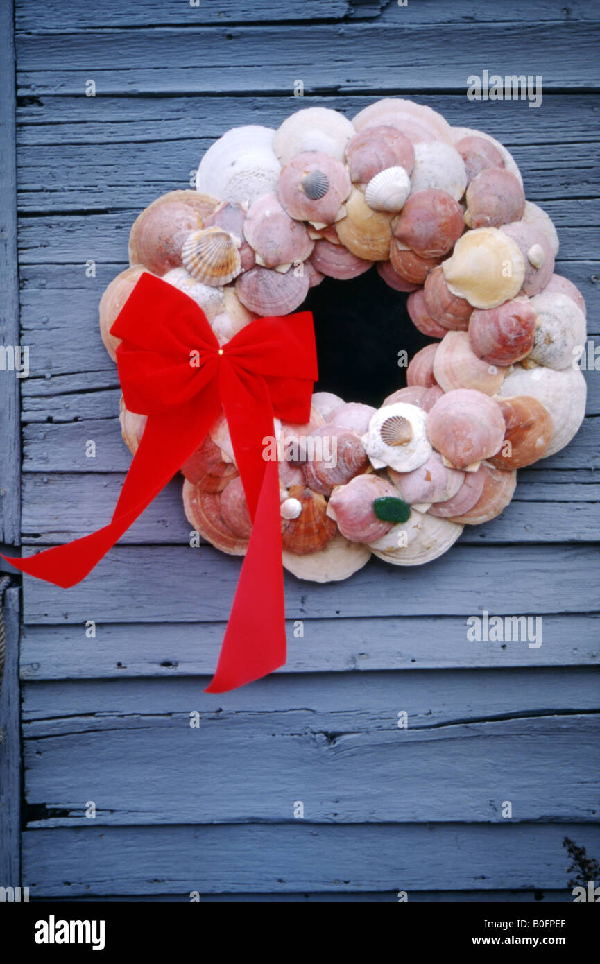 Door decoration made from sea shells and tied with a red ribbon bow fastened to a wooden door near Edgartown,Martha's Vineyard. Stock Photo