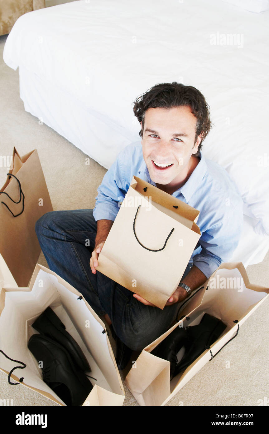 Man smiles holding shopping bags Stock Photo - Alamy