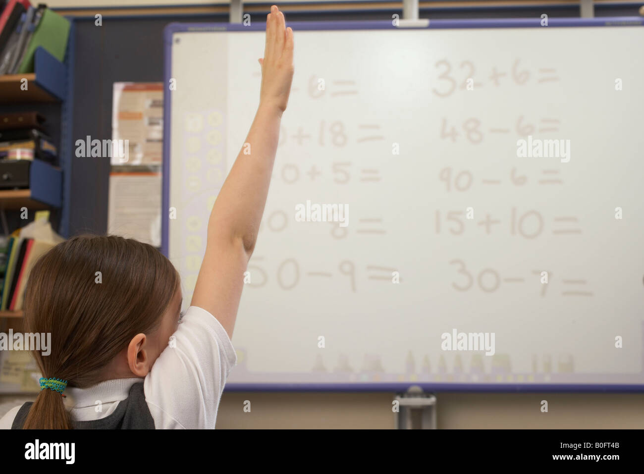 Girl raising her hand in classroom Stock Photo - Alamy