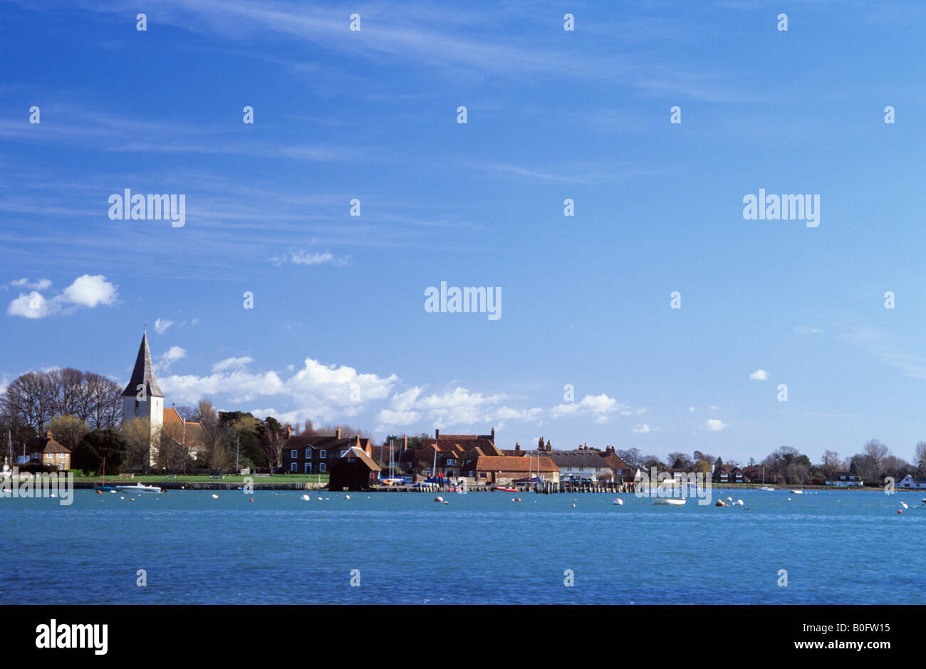 BOSHAM VILLAGE from CHIDHAM across one of the channels in Chichester harbour on the south coast West Sussex England UK Stock Photo