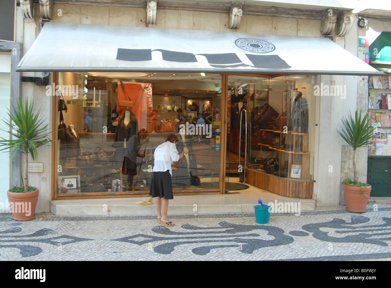 A shop assistant cleaning the windows before opening for business on an
