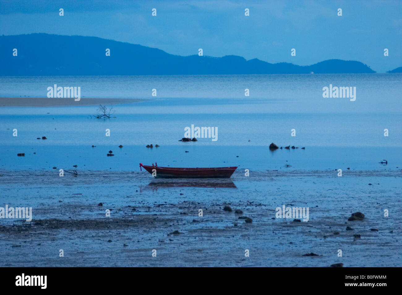 Tranquil scene of depressive blue with lonely boat on sandbank during ...