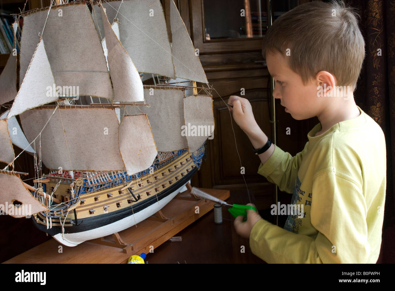 Teen boy building a ship model Le Solei Royal Stock Photo