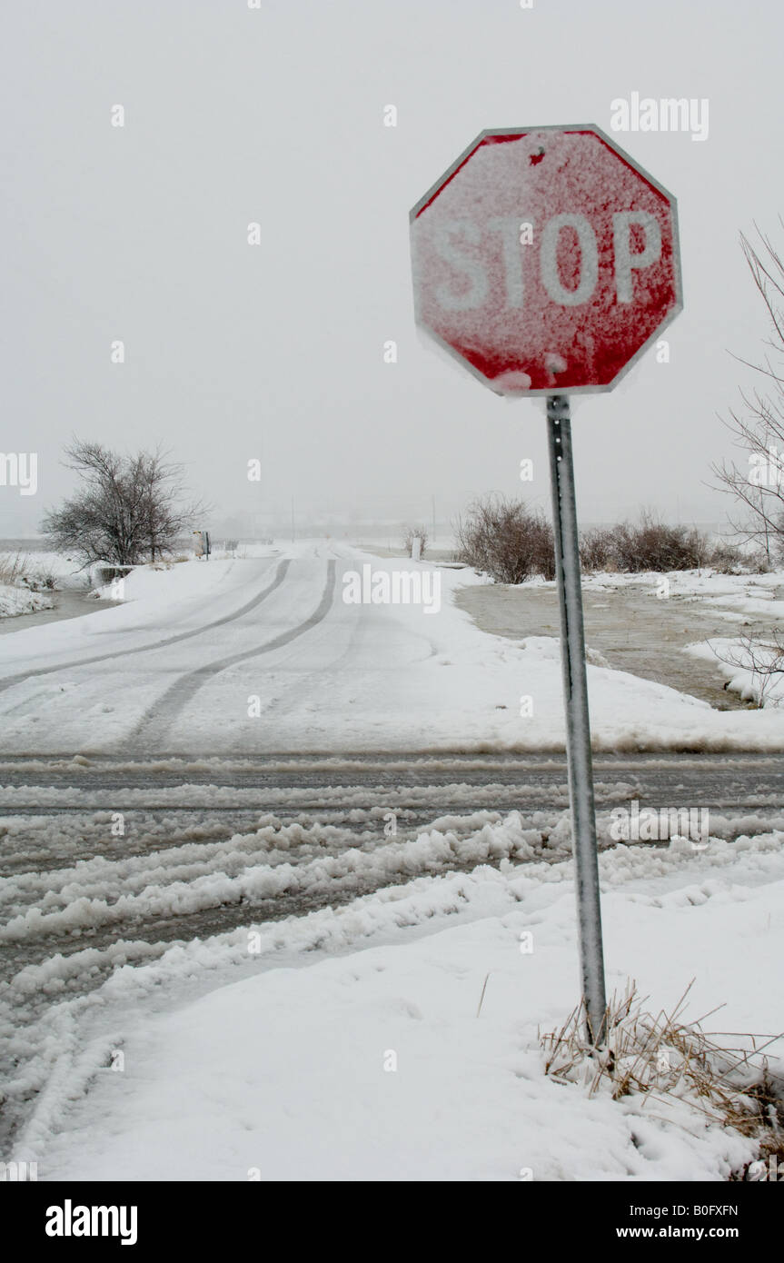 Bad winter weather makes its' make on this rural stop sign with frozen ice. Stock Photo