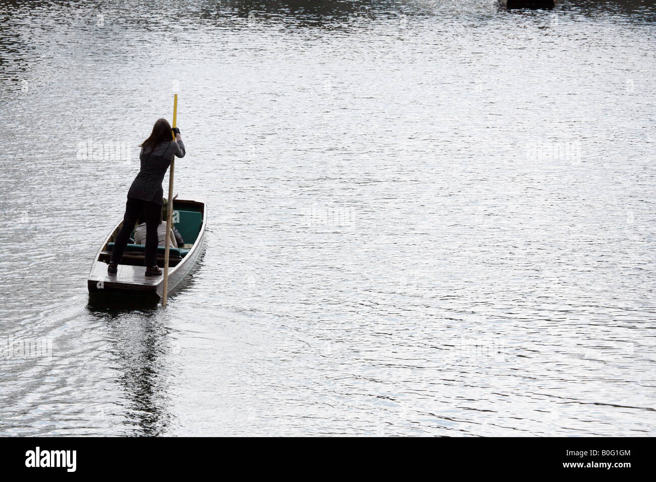A girl punts a boat along the river Cam, Cambridge England Stock Photo