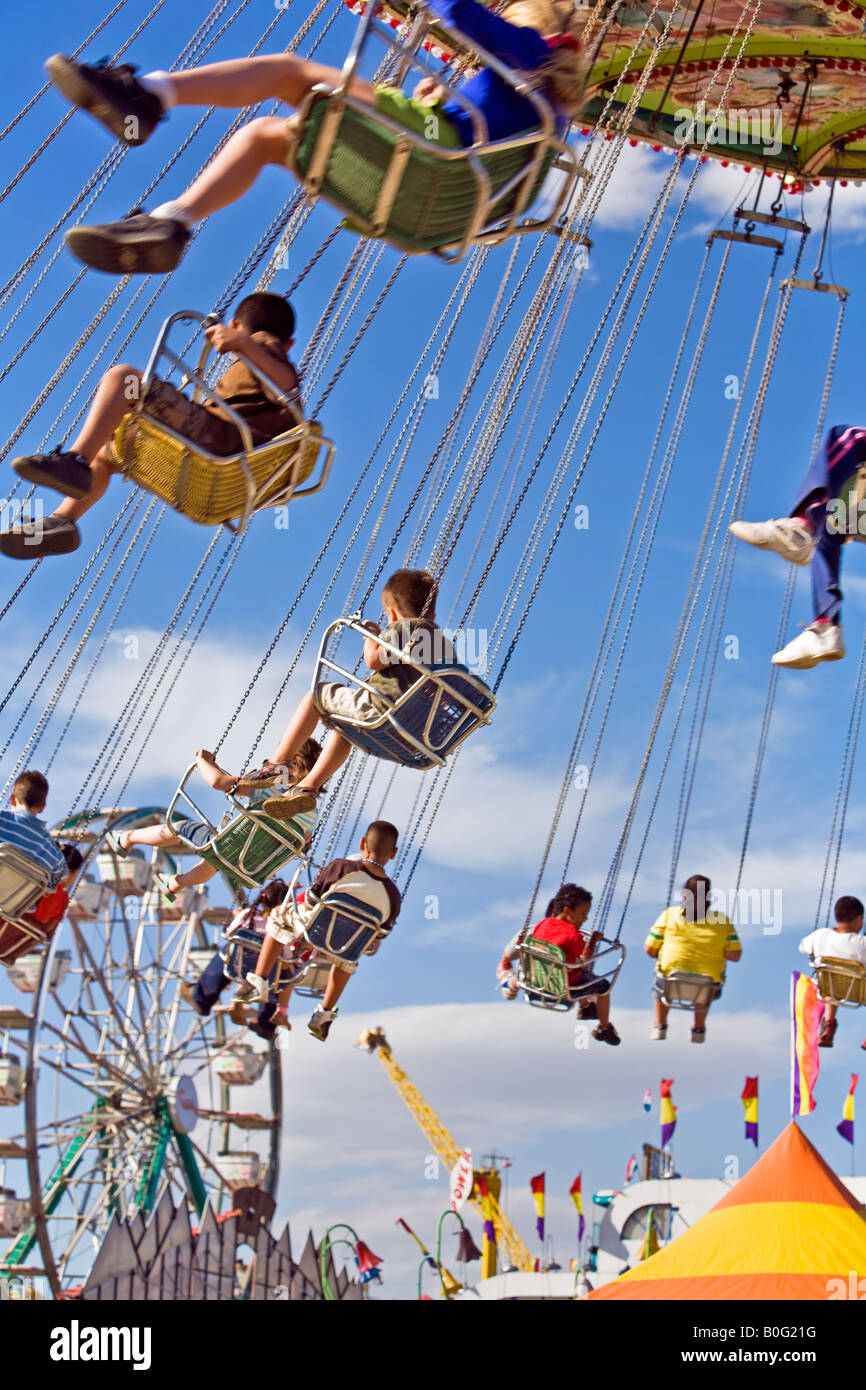 Kids on a Carnival swing ride high above the ground Stock Photo - Alamy