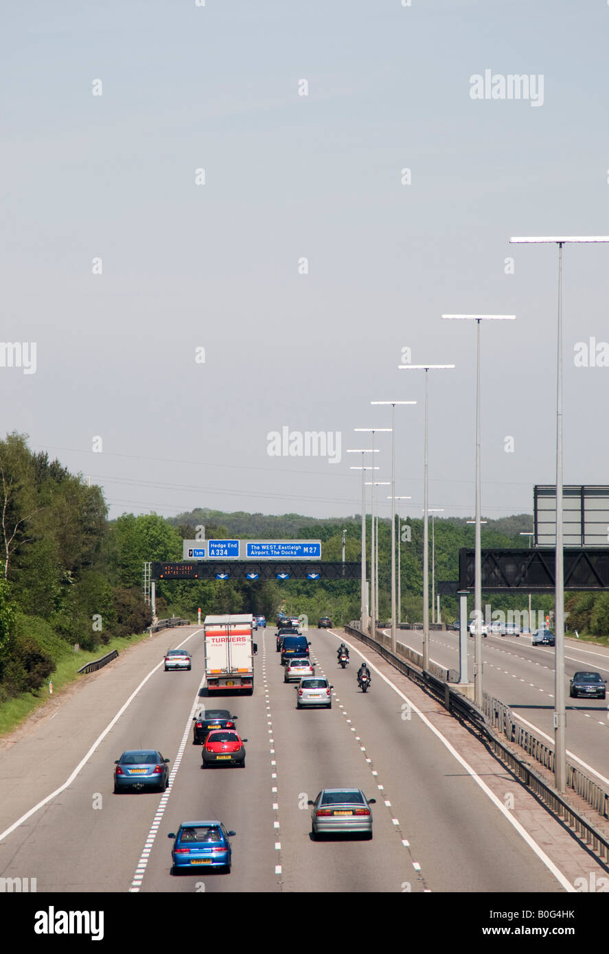 Motorway traffic on the M27 near Southampton England on a normal day showing various signs gantries and lane marking etc Stock Photo