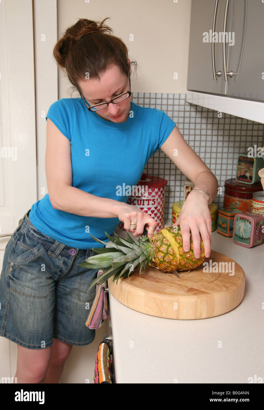 Female cutting a pineapple Stock Photo