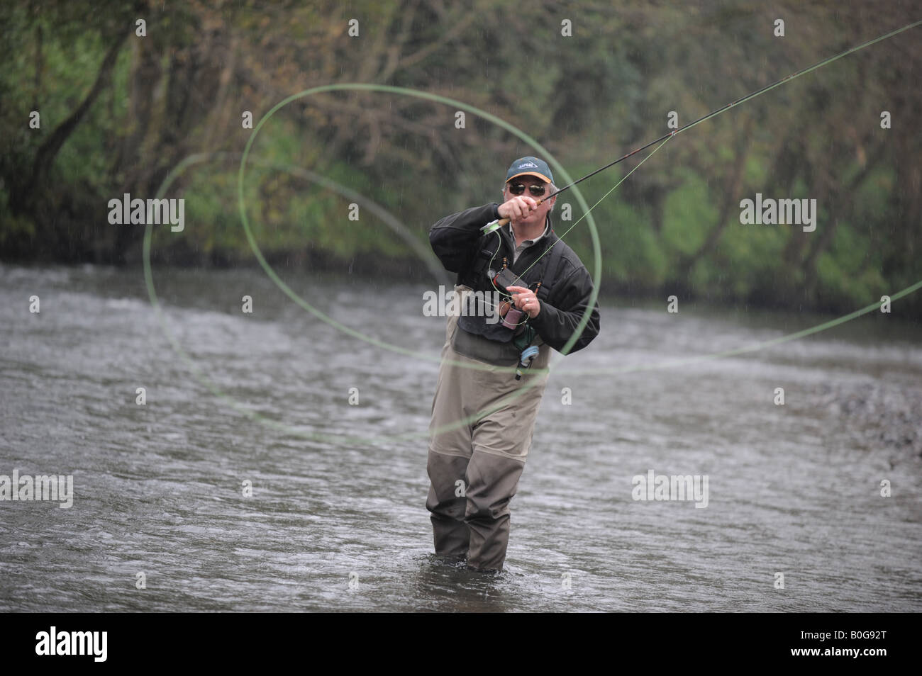 Gary Champion fly fishing and casting his line on the River Lyd, near Lifton, Devon, UK Stock Photo
