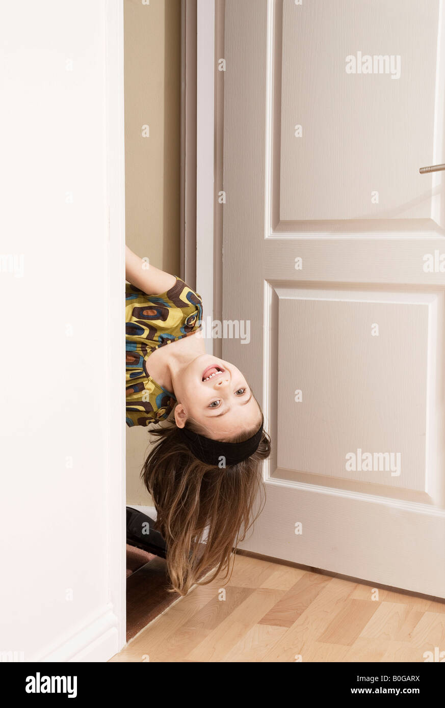 Girl poking her head round a door Stock Photo