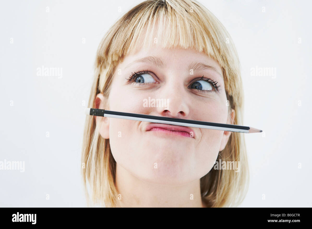 Amusing woman with pencil above mouth Stock Photo - Alamy