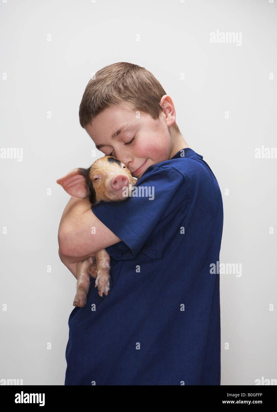 Boy hugging piglet Stock Photo