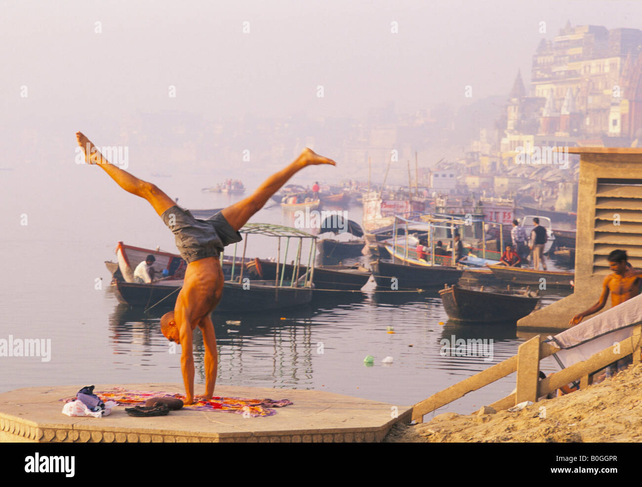 Man practicing yoga by the River Ganges, Varanasi, India. Stock Photo