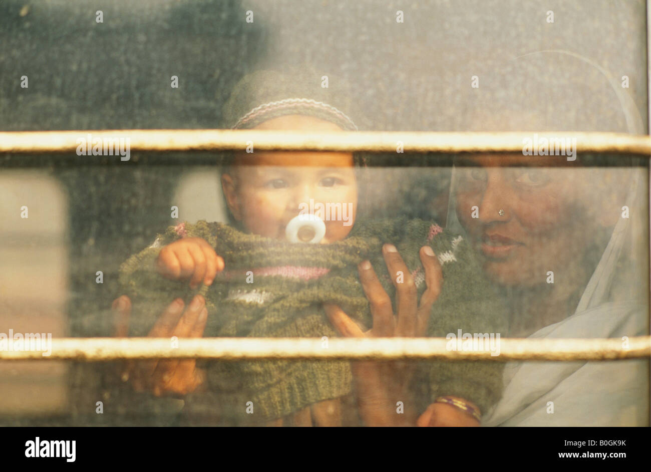 A mother holding her baby up to the window in a train, Pakistan. Stock Photo