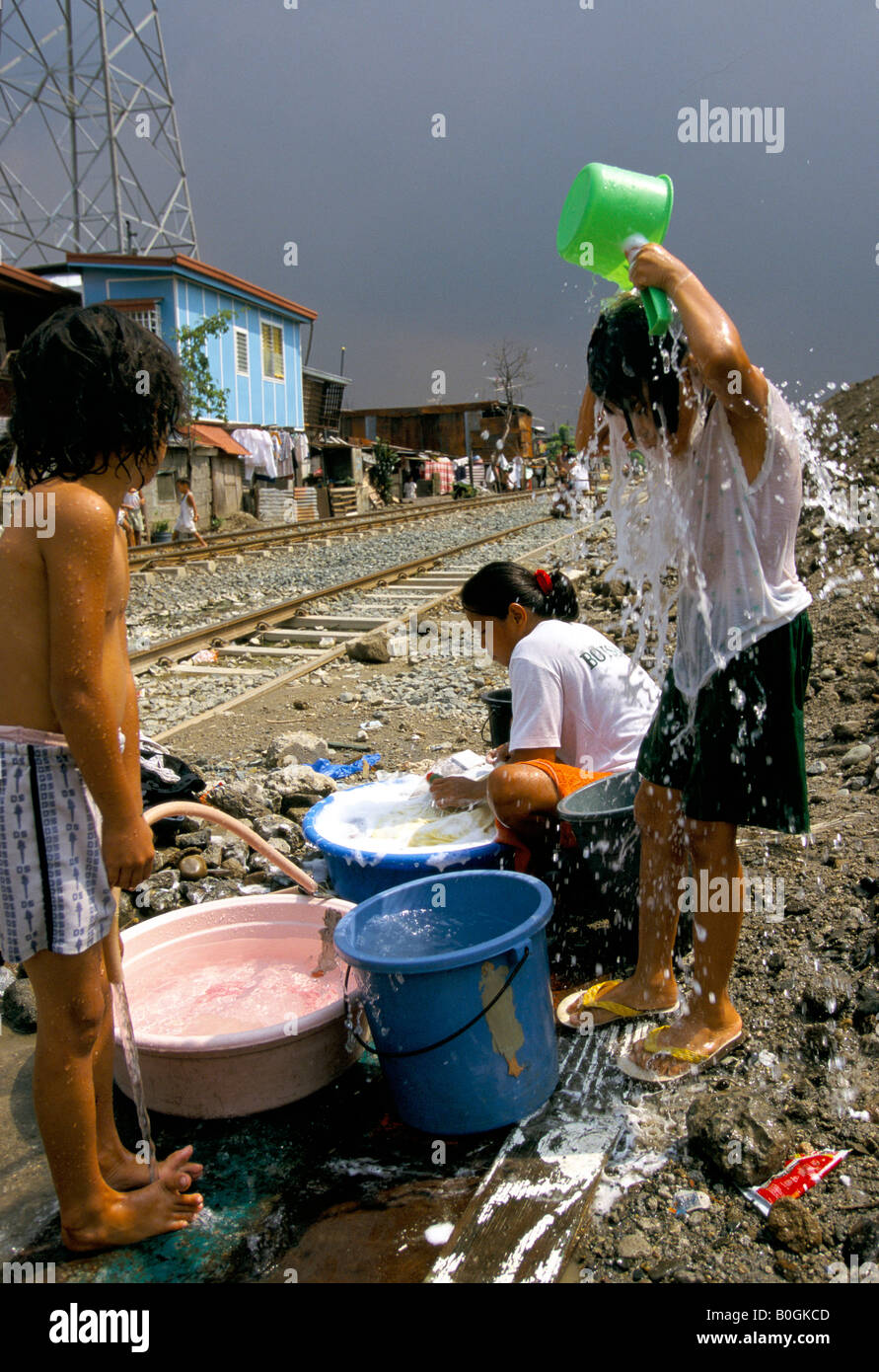 Children using an illegal water connection for laundry and bathing