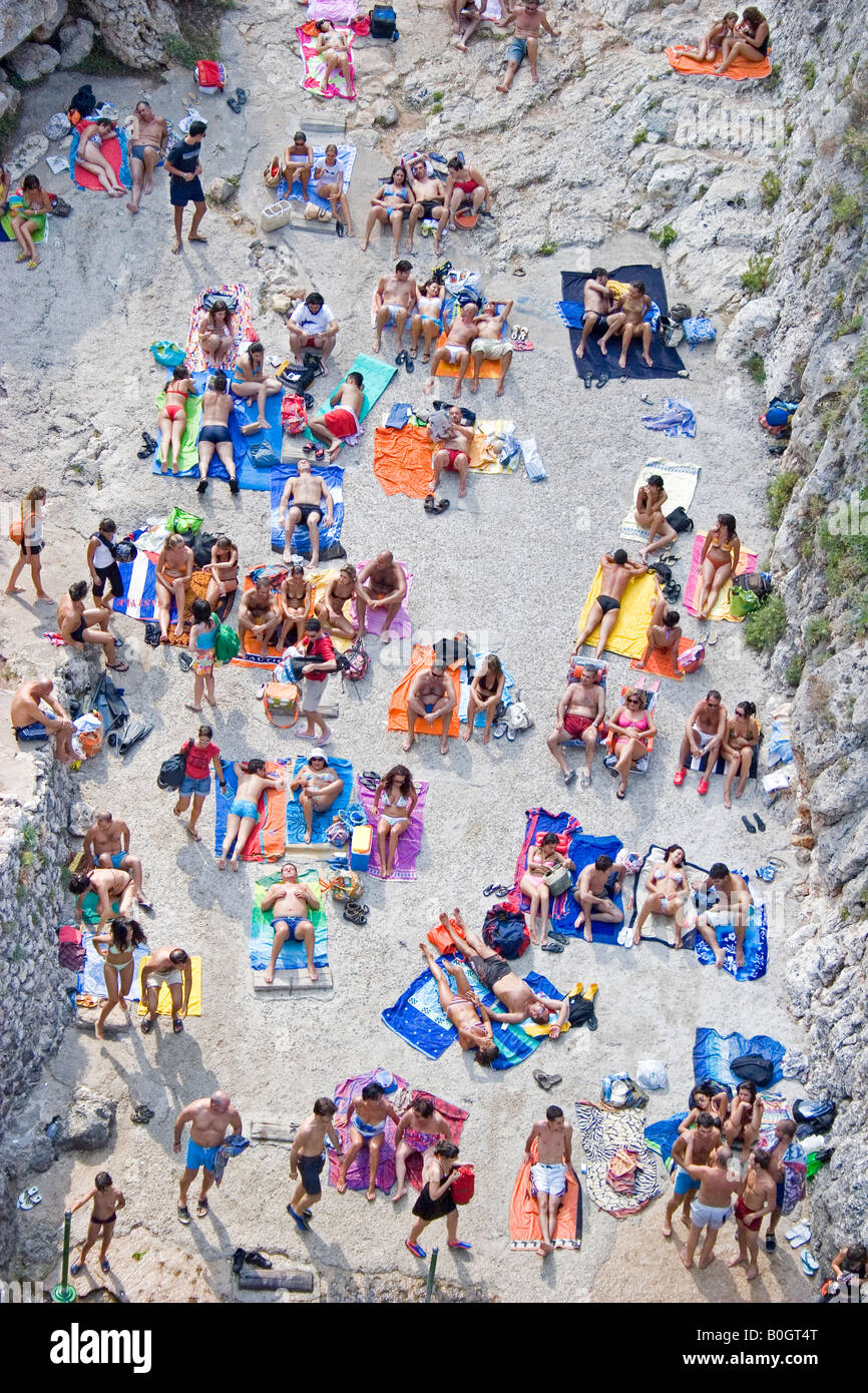 PEOPLE SUNBATHING AND ENJOYING THE SUN ON THEIR COLOURED SEA TOWELS ...