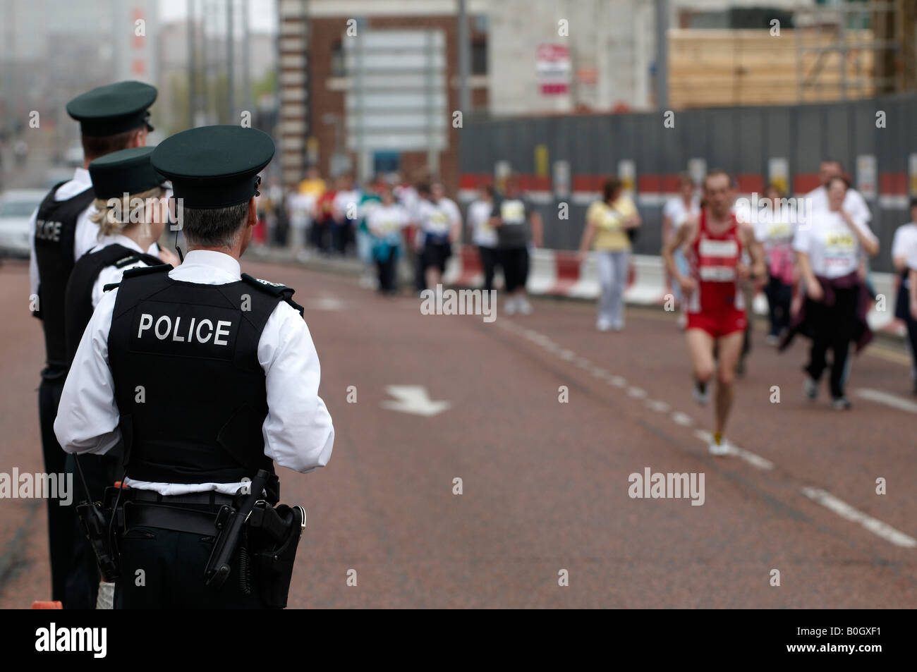 PSNI Officers watch runners in the Belfast Marathon Stock Photo