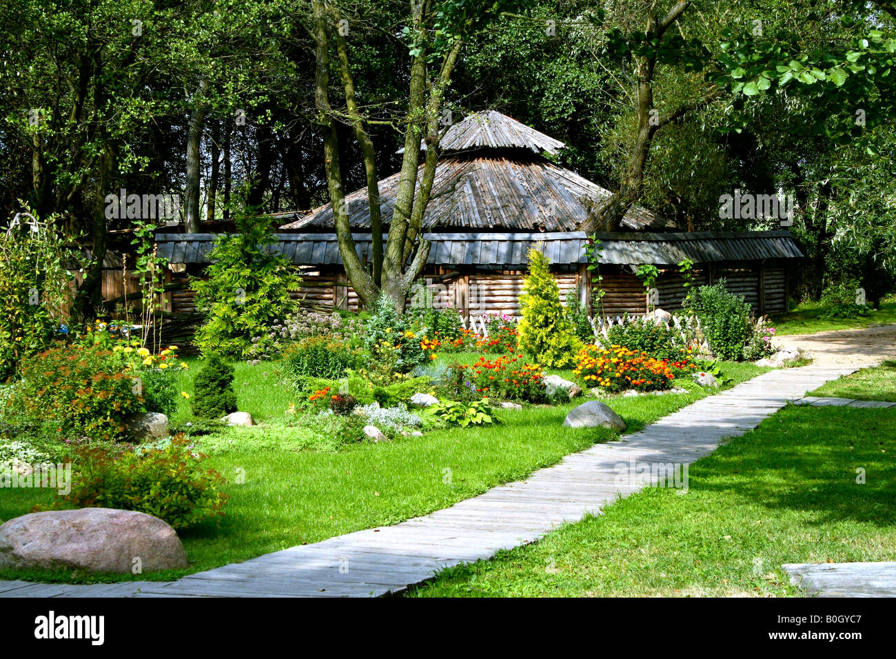 Wooden Hut in a green grassy meadow field at Dudutki Village, Belarus September, 2007 Stock Photo