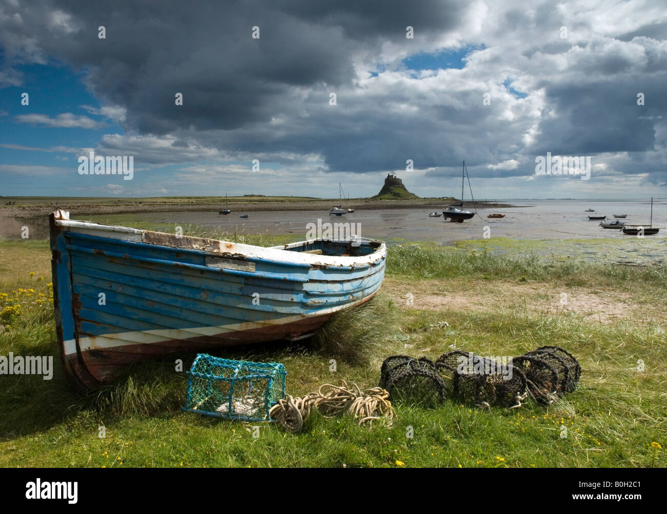 Rowing boat taken at Lindisfarne Island in Northumbria England showing Lindisfarne Castle in the background. Stock Photo