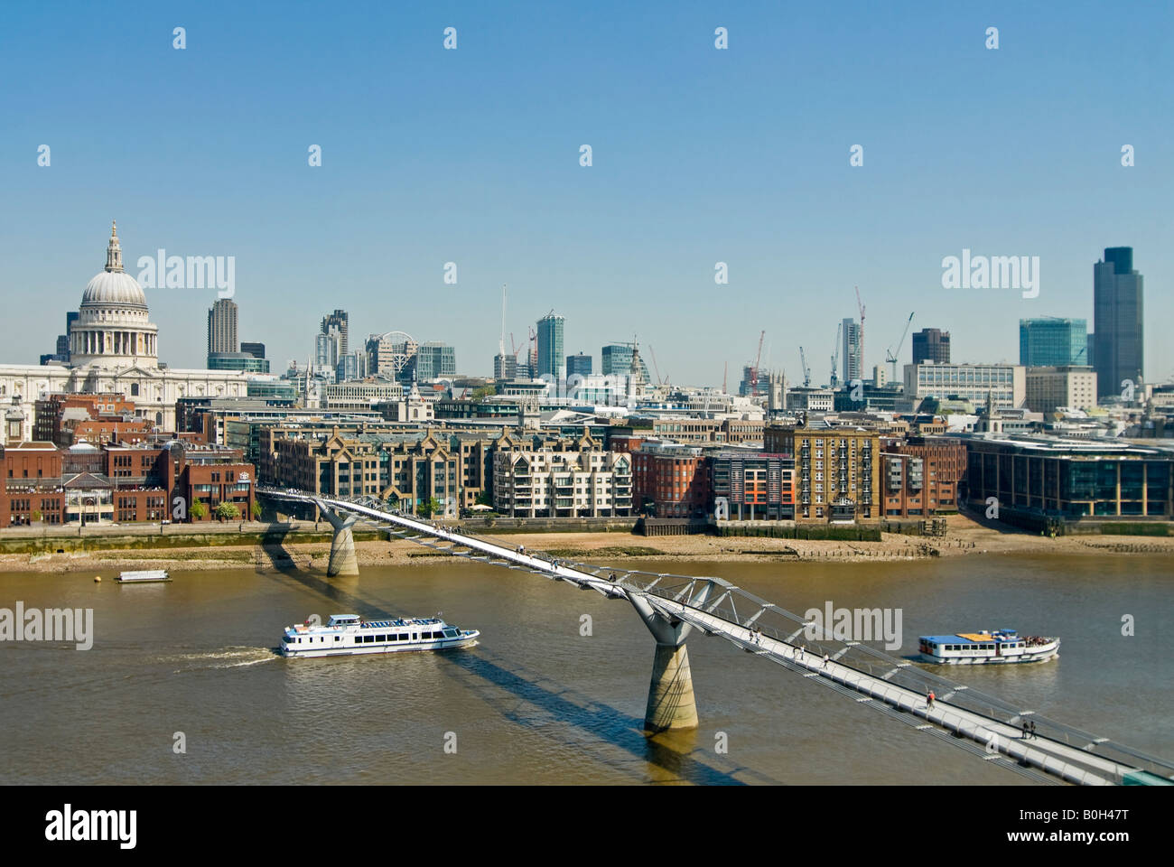 Horizontal aerial view over London of St Paul's Cathedral and the Millenium Bridge (aka Wobbly Bridge) on a bright sunny day. Stock Photo