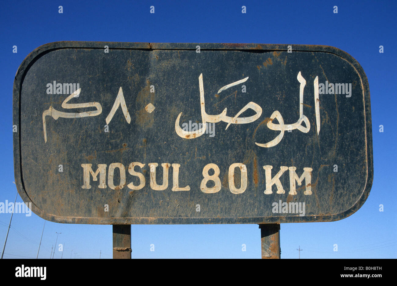 Road sign, 'Mosul 80 km' on a country road near Hatra, Iraq, Middle East Stock Photo