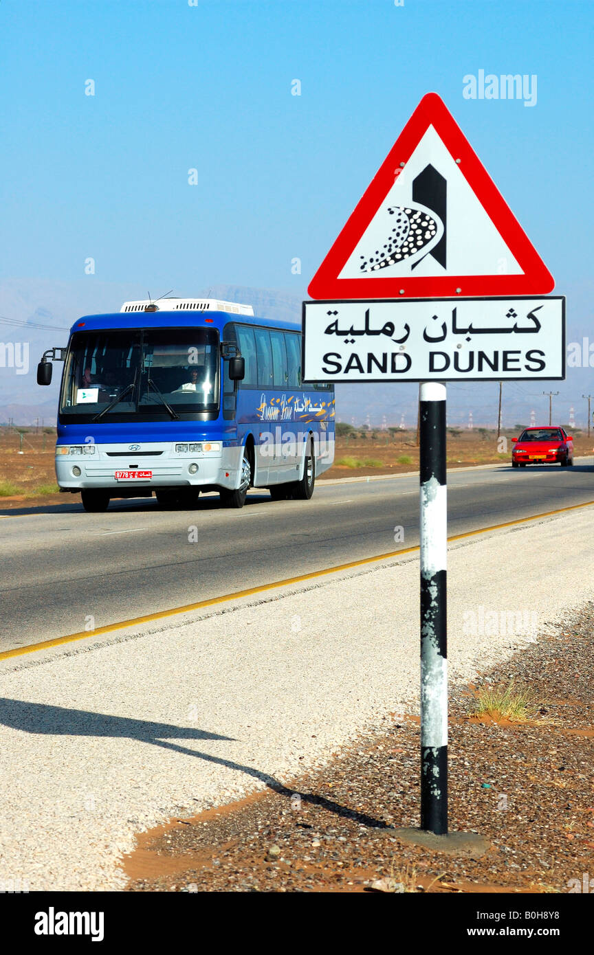 Road sign warning against encroaching sand dunes posted alongside the Wahiba Sands Desert, Ramlat al Wahaybah, Oman, Middle East Stock Photo