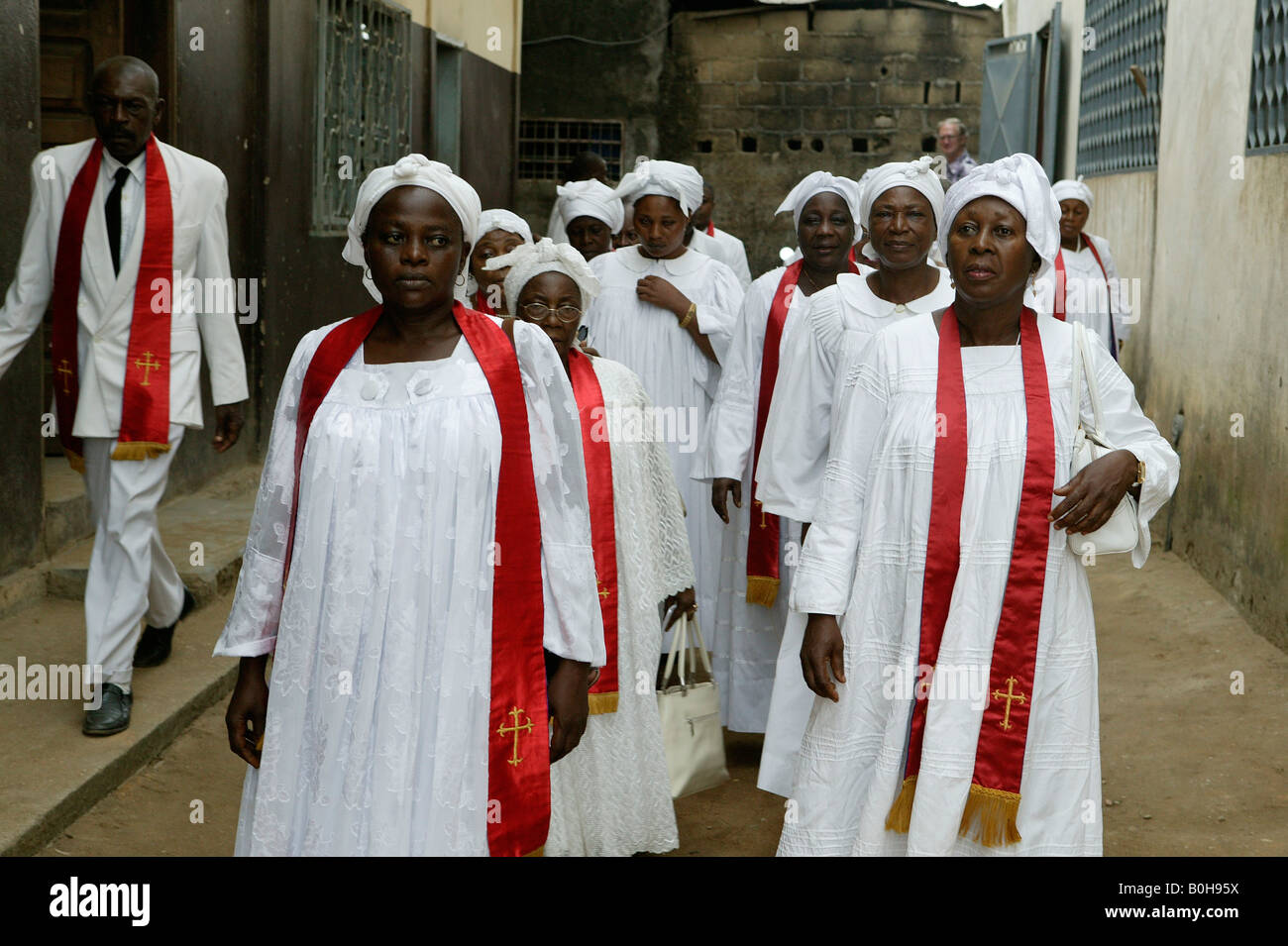 Women dressed in white robes and red sashes at a church service in Douala, Cameroon, Africa Stock Photo