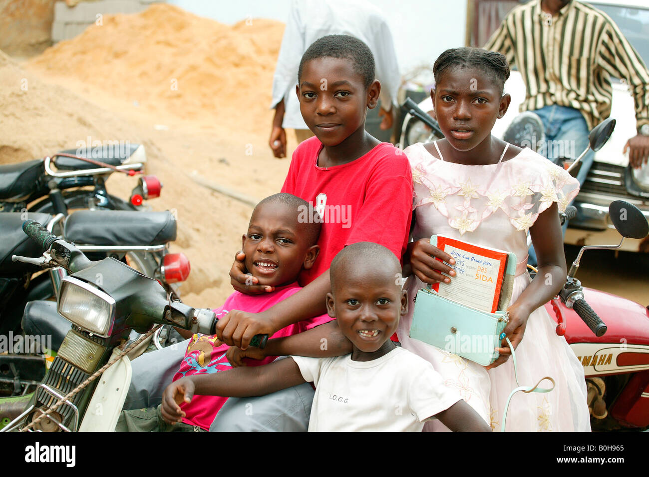 Four children sitting on a motor scooter Douala, Cameroon, Africa Stock Photo
