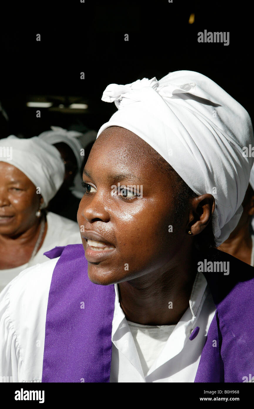 Woman dressed in white with purple sash at a church service in Douala, Cameroon, Africa Stock Photo
