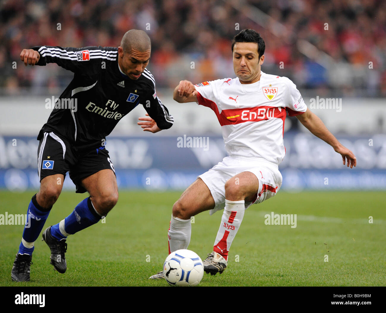 Football tackle, Hamburger SV footballer Nigel de Jong (left) against VfB Stuttgart player Yildiray Bastuerk (right) Stock Photo