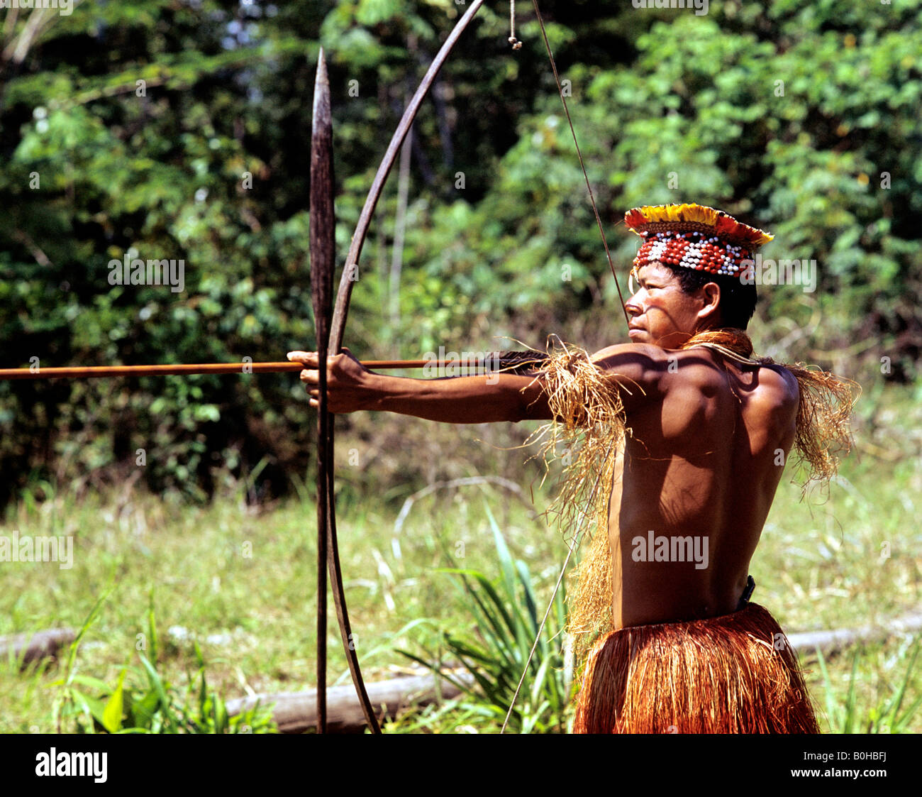 Indian, indio or indigenous warrior pointing a bow and arrow, Amazon, Iquitos, Peru, South America Stock Photo