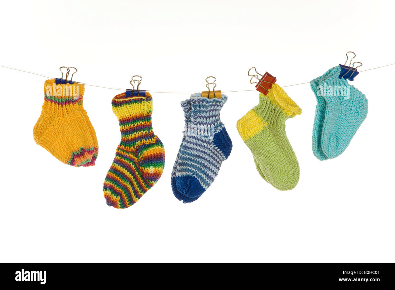 Various baby socks hanging from a clothesline Stock Photo