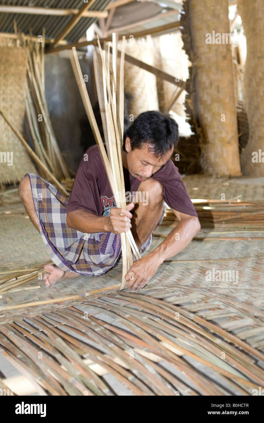 Worker making bamboo mats in a bamboo furniture factory, Lombok Island, Lesser Sunda Islands