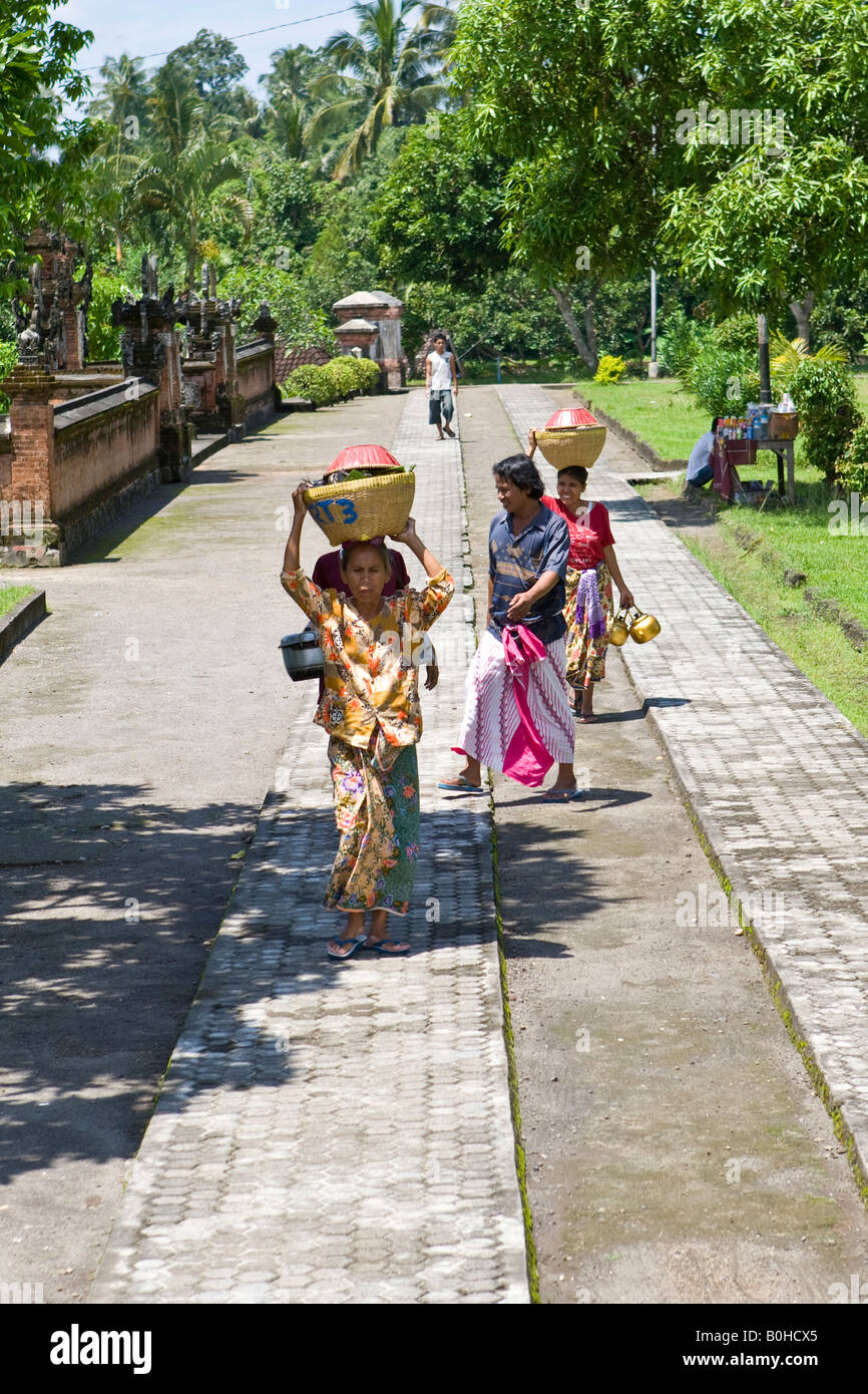 Women carrying basket of fruit on their heads at the entrance to the