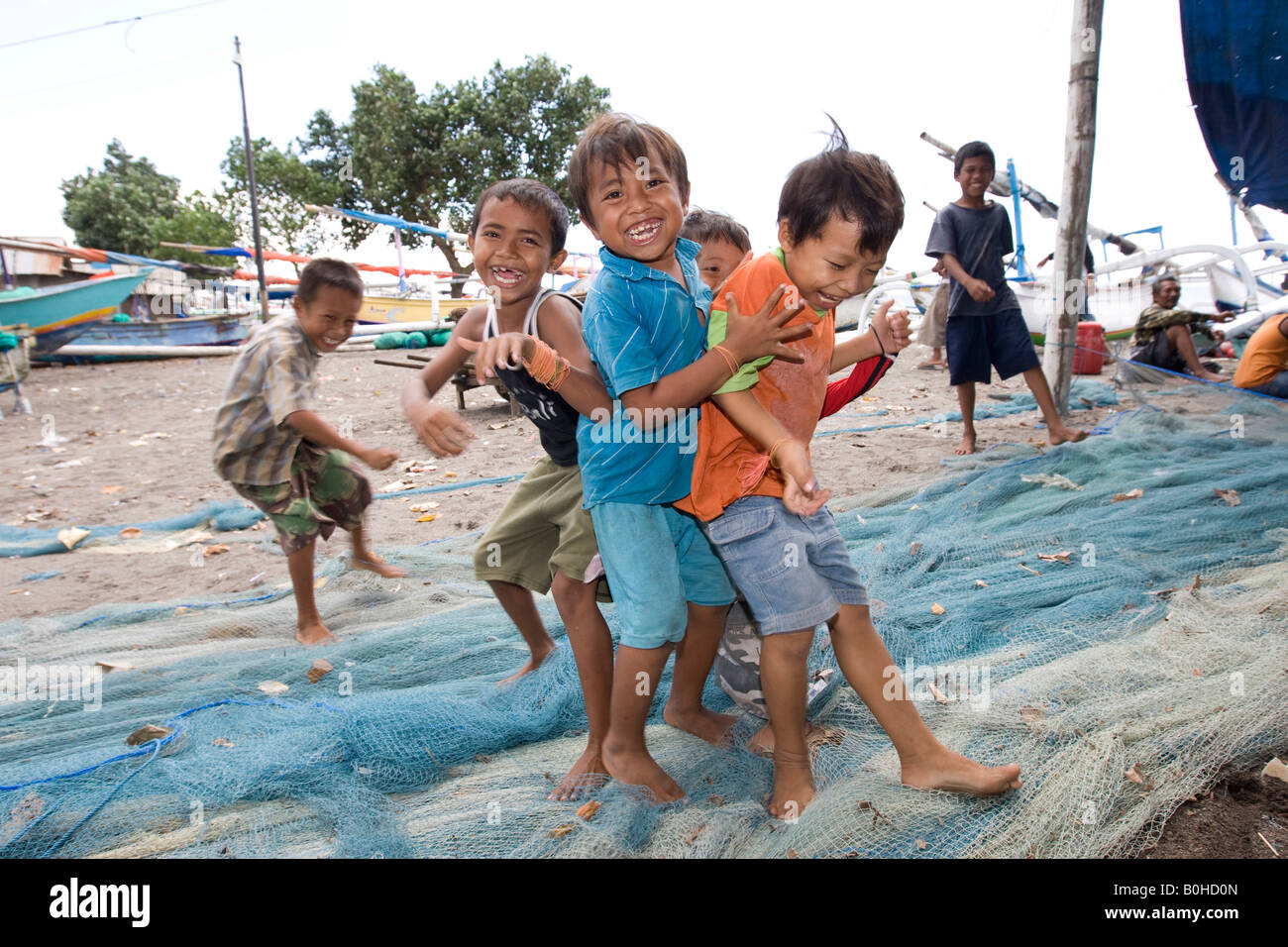 Children playing on fishing nets in the harbour, Lombok Island, Lesser