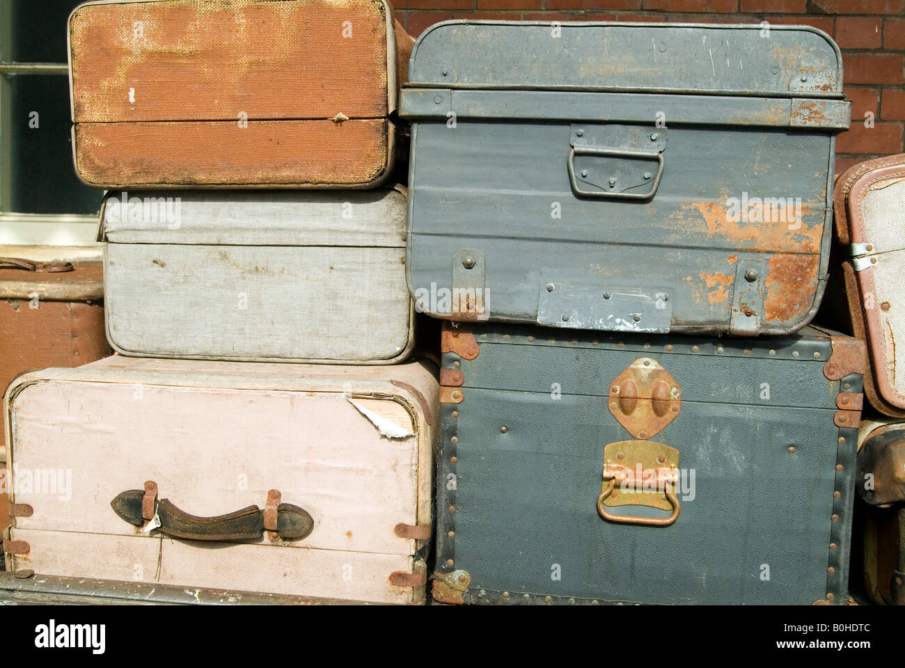 Worn old suitcases stacked on a railway platform Stock Photo