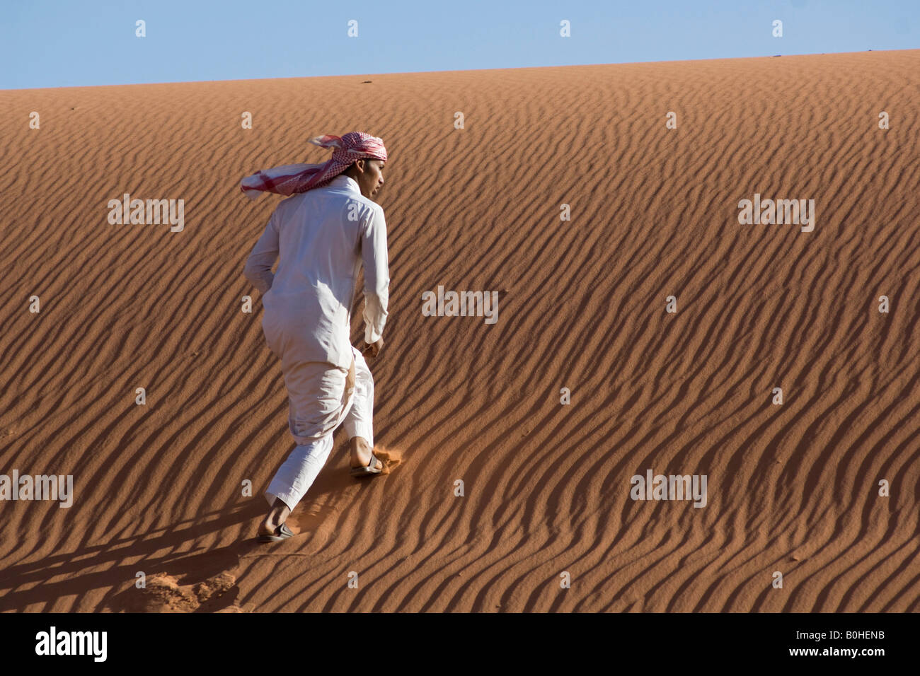 Bedouin climbing a sand dune, ripples, Wadi Rum, Jordan, Middle East Stock Photo