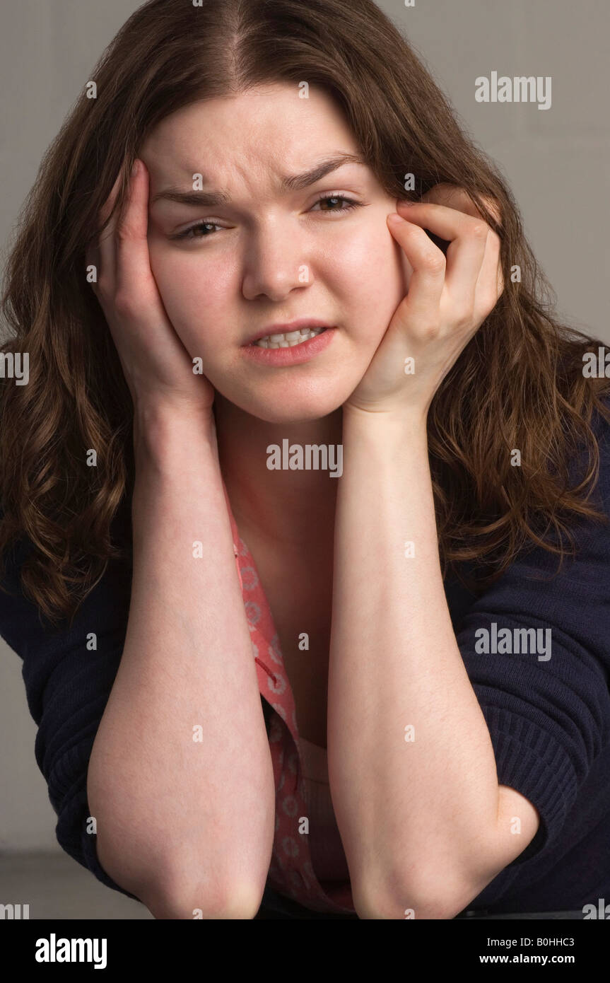 Young woman with head in hands Stock Photo
