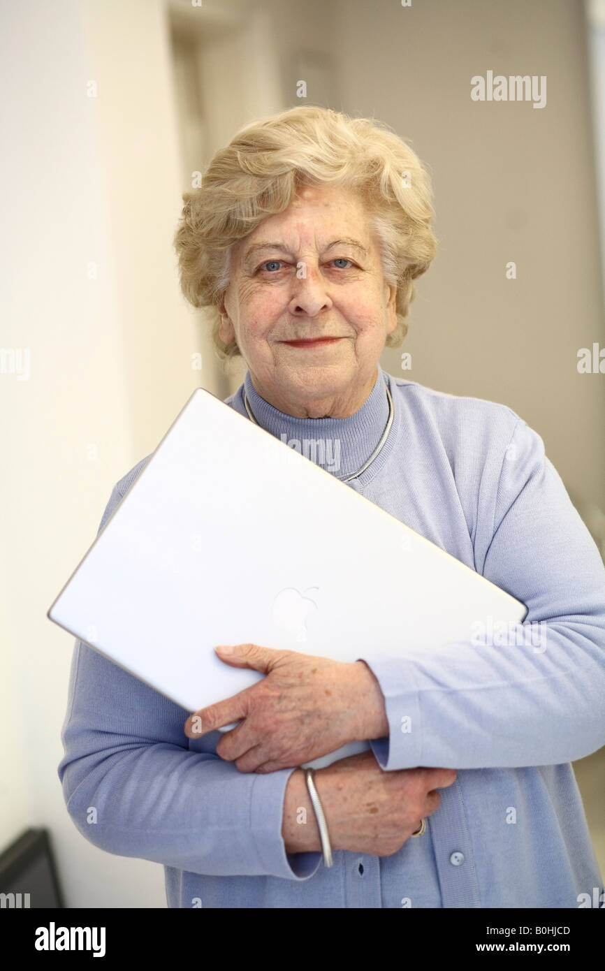 Senior woman holding a laptop Stock Photo