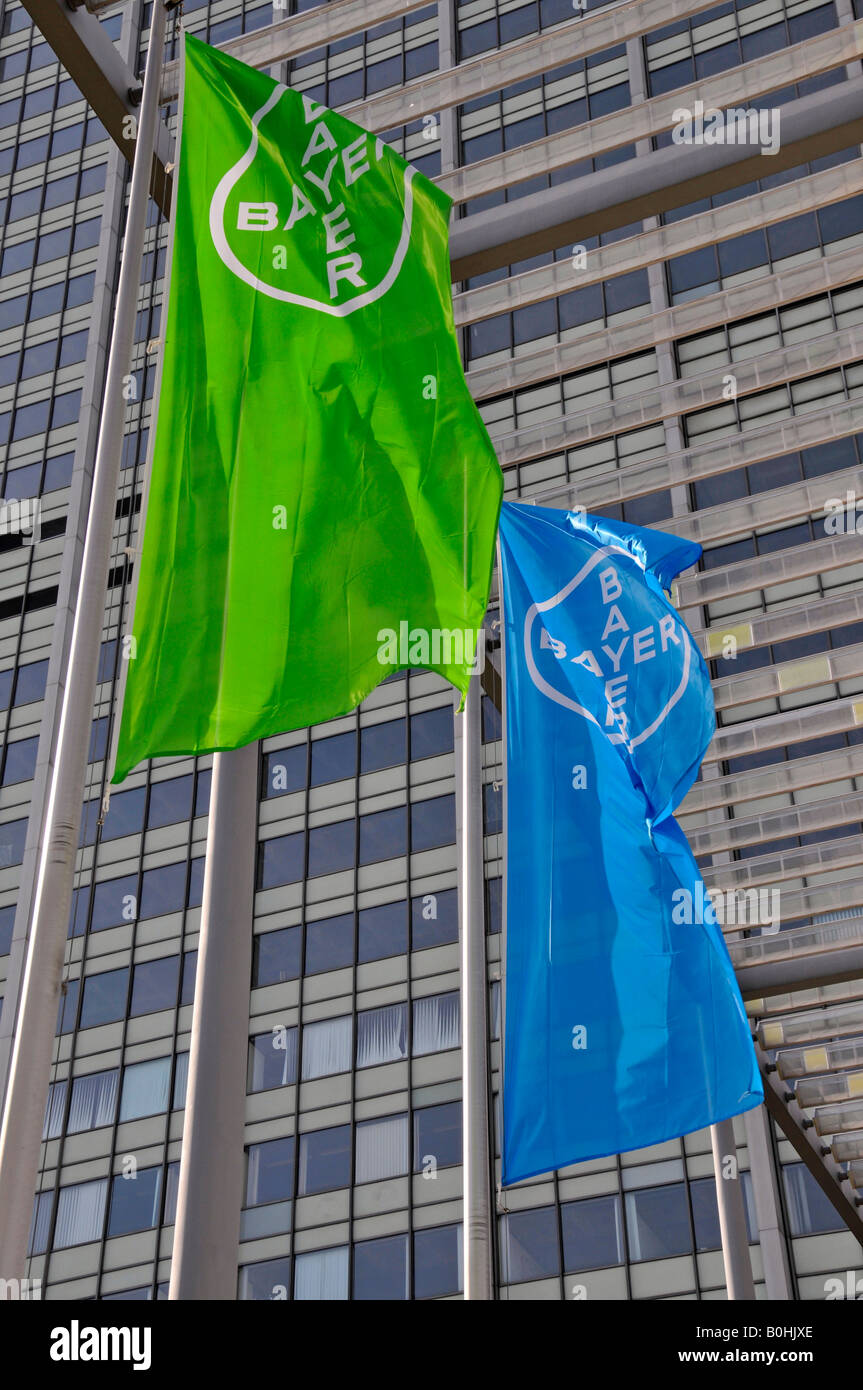 Blue and green flags of the Bayer corporation visible against a high