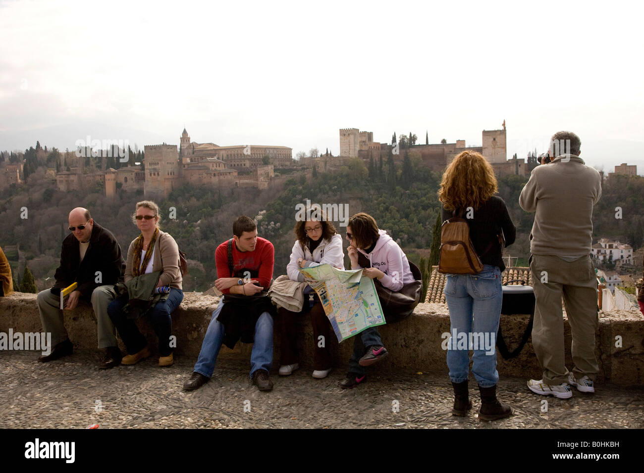 Tourist enjoying the view of the Moorish Alhambra Palace from the Mirador San Nicolas in the El Albayzín or Albaicín quarter of Stock Photo