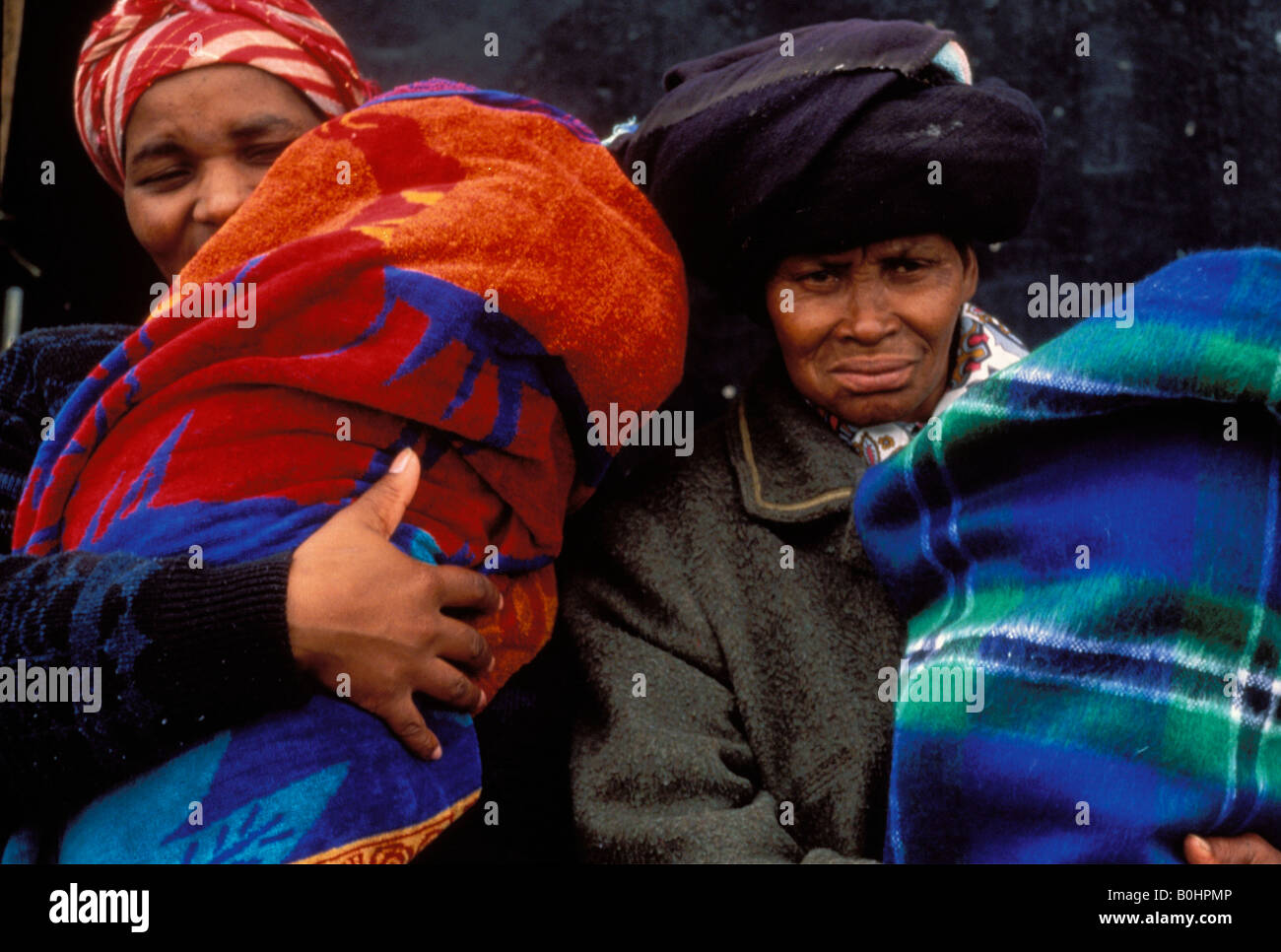 Women holding babies wrapped in blankets against the cold, South Africa