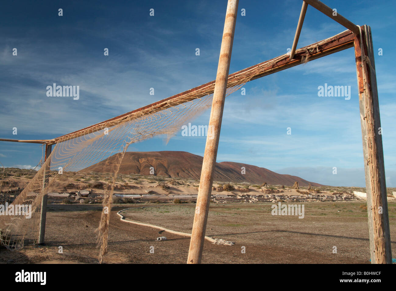 Rusting goal posts and torn net Stock Photo