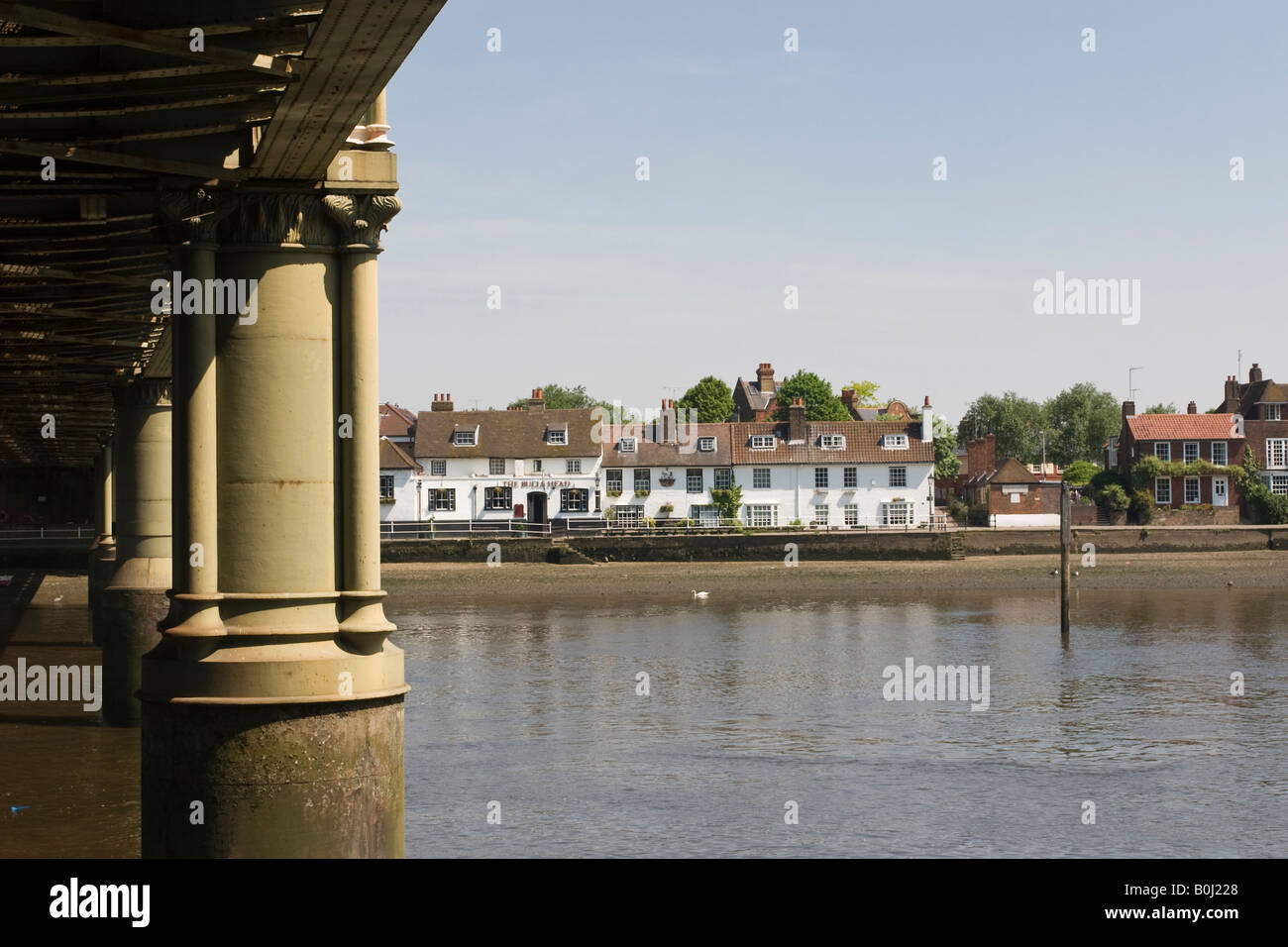 View from Kew to the Bulls Head Inn Strand on the Green Chiswick and the carved stone supports of Kew Railway Bridge Stock Photo