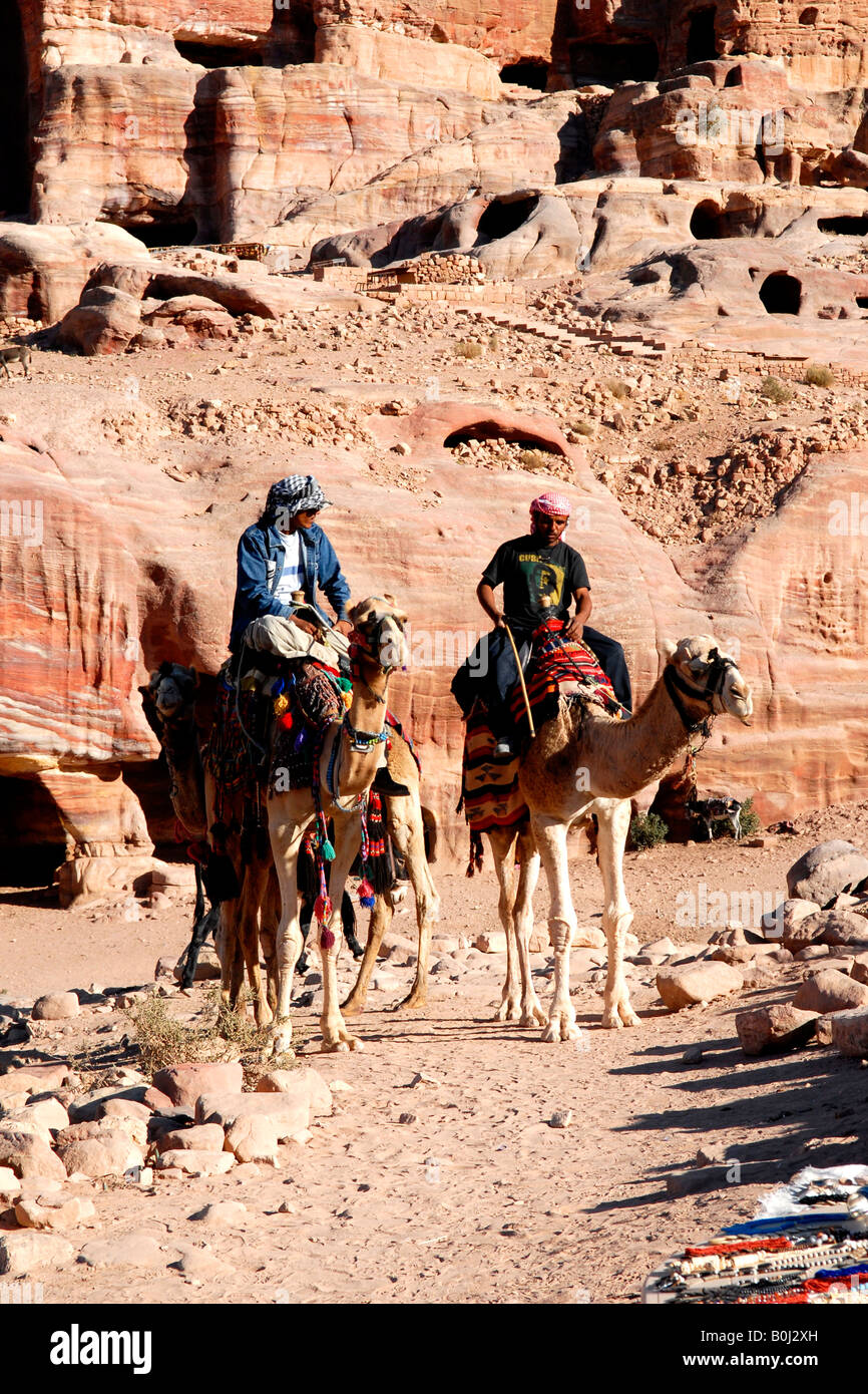 taxa koloni Optø, optø, frost tø Beduin or Bedouin Arabs on camels with hand crafted saddles by pink & red  hills with caves of ancient Petra Kingdom of Jordan Stock Photo - Alamy