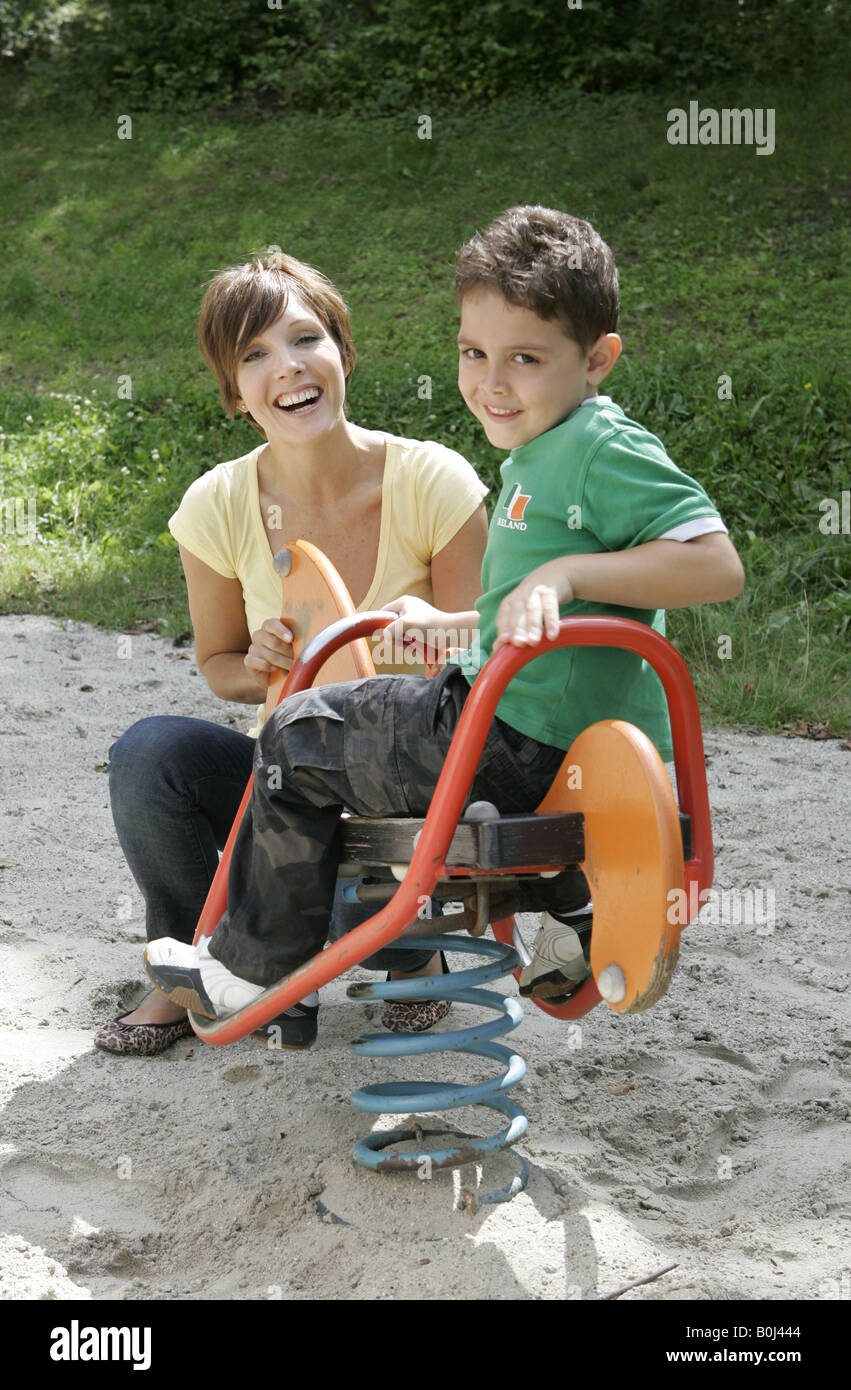 Mother with her young son playing in a playground Stock Photo - Alamy