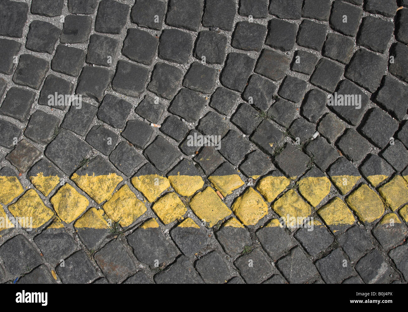 Single yellow parking line on cobbled street Stock Photo Alamy