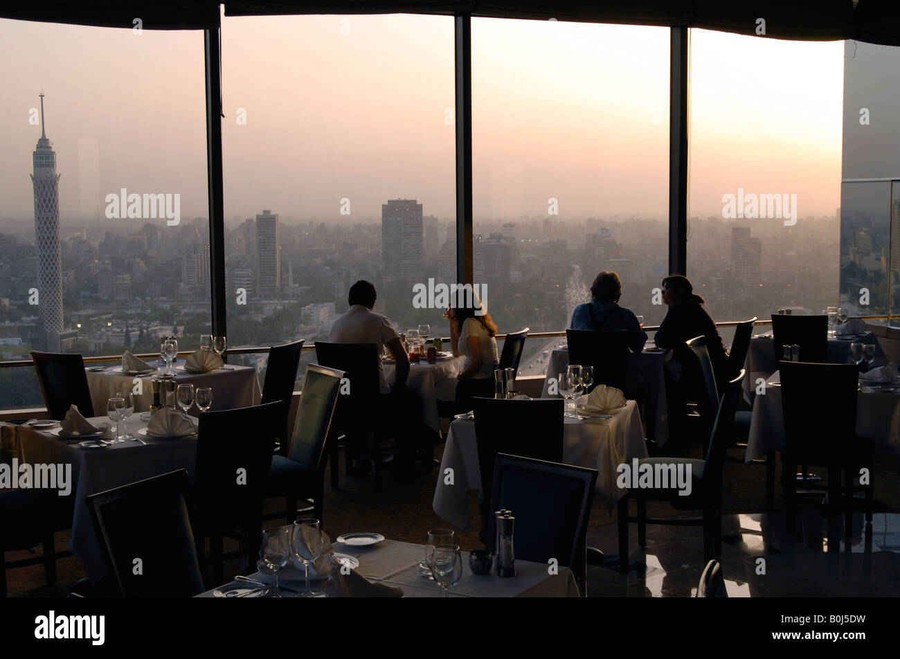 Diners at the Windows on the World restaurant atop of the Ramses Hilton hotel with views of Cairo at sunset Egypt Stock Photo