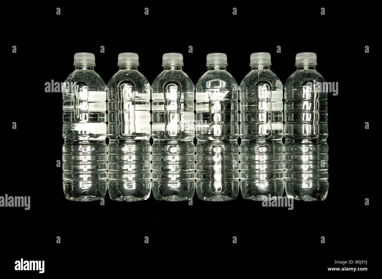 Clear plastic water bottles on a black background Stock Photo - Alamy