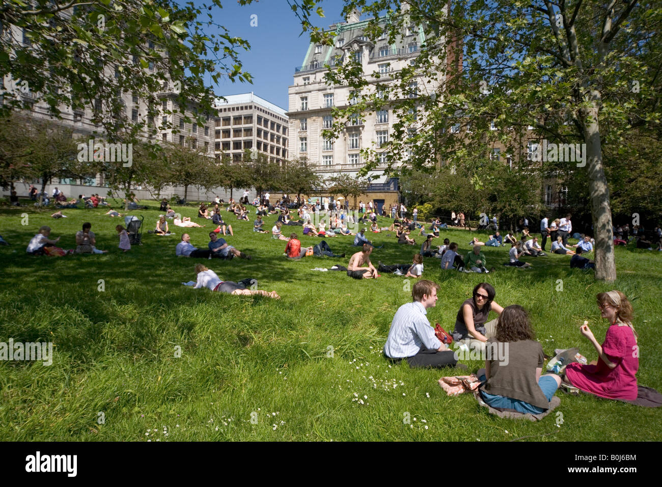 Dejeuner sur l'Herbe; Office workers relax in May Heatwave Green Park London Stock Photo